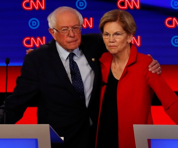 elizabeth warren and bernie sanders stand arm in arm