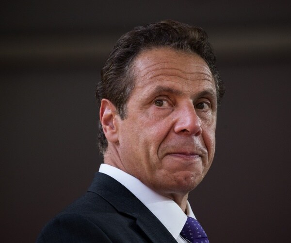 cuomo in a black suit and bright blue tie