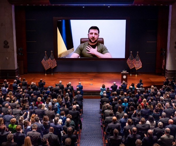 zelensky on video screen as congress members are seated in an auditorium