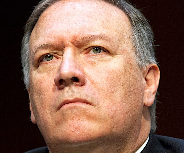 mike pompeo looks up with a stern face during a congressional hearing