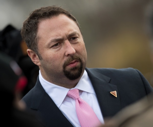 miller in a black suit and pink striped tie