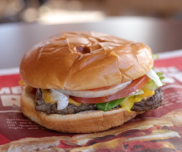 a Wendy's cheeseburger with lettuce on the Wendy's wrapper