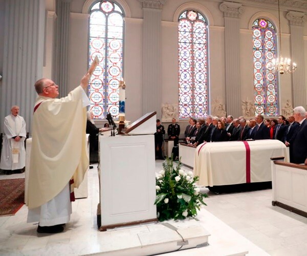 father patrick conroy holds up a bible