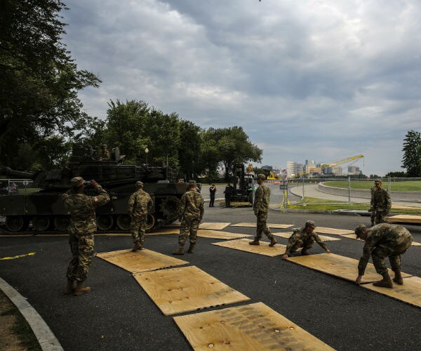 military personnel watch as an M1 abrams is driven on pads toward the front of the Lincoln Memorial 