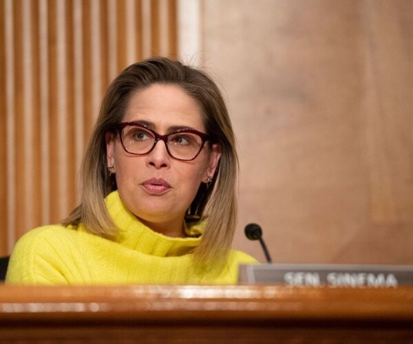 Kyrsten Sinema speaks into a microphone