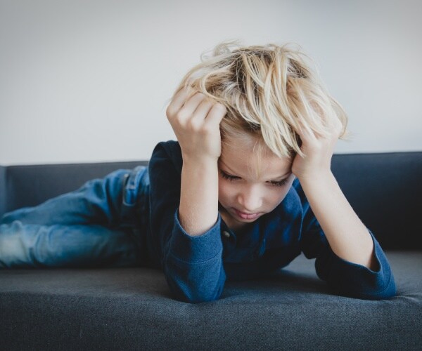 boy with head in hands in anxiety