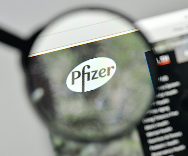 a photo illustration of the pfizer website with a magnifying glass highlighting the logo