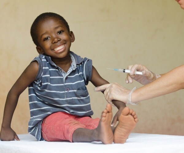 young boy smiling, getting a vaccine