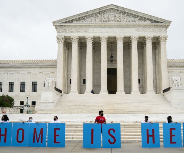 daca recipients and their supporters rally outside the supreme court holding blue and red signs in washington