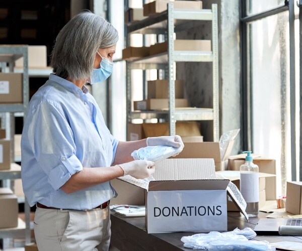 older woman volunteering by going through donations