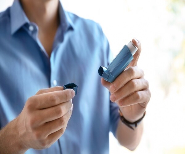 A young man opening an inhaler