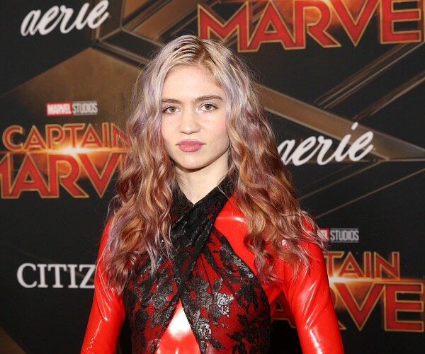 grimes stands on red carpet