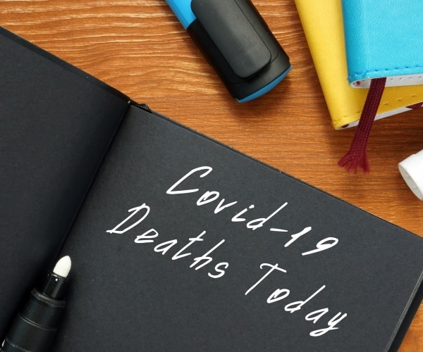 COVID-19 Deaths written in notebook