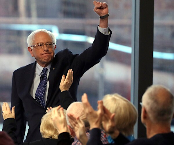 bernie sanders pumps his left fist high into the air