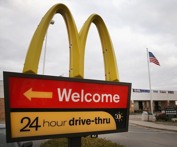 mcdonalds arches are next to an american flag