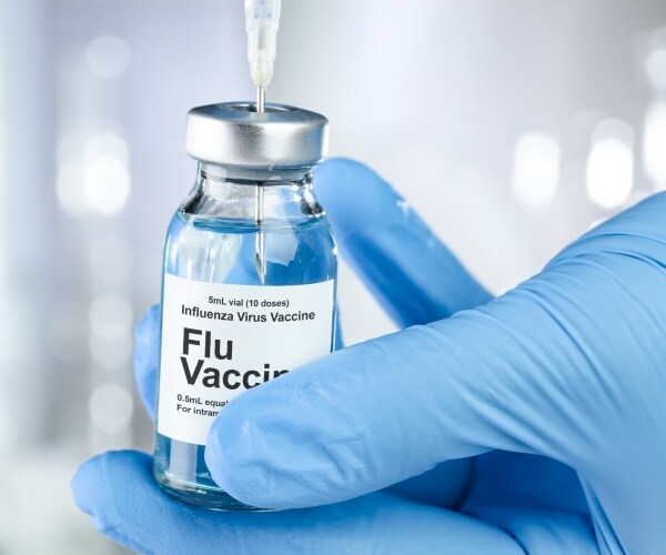 vial labeled flu vaccine and a syringe