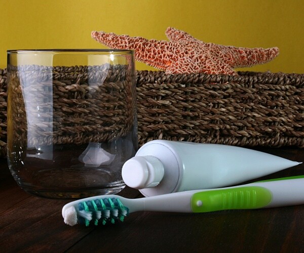 toothbrush, toothpaste and water glass