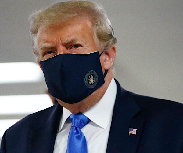 president donald trump walks through walter reed hospital with a mask on