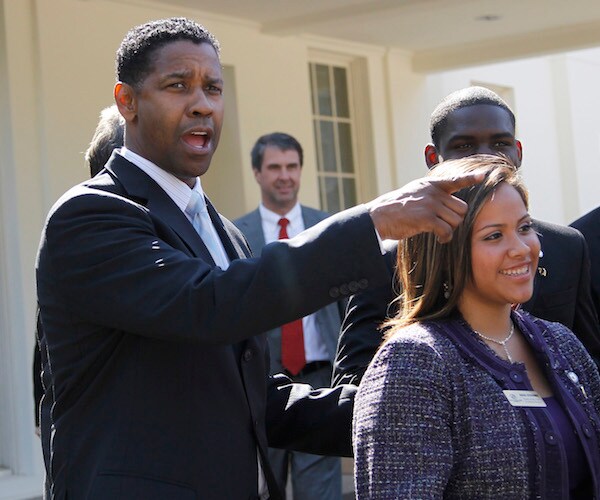 Denzel Washington points and speaks to the media