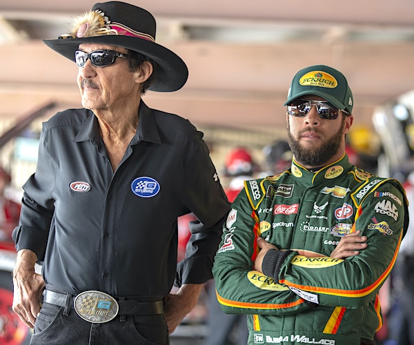 richard petty and bubba wallace stand in the garage before a nascar race