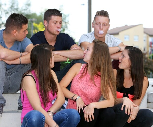 teenaged boys and girls chewing gum