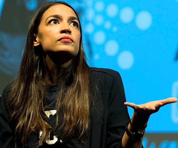 socialist democrat representative from new york alexandria ocasio-cortez looks up and throws her left palm up