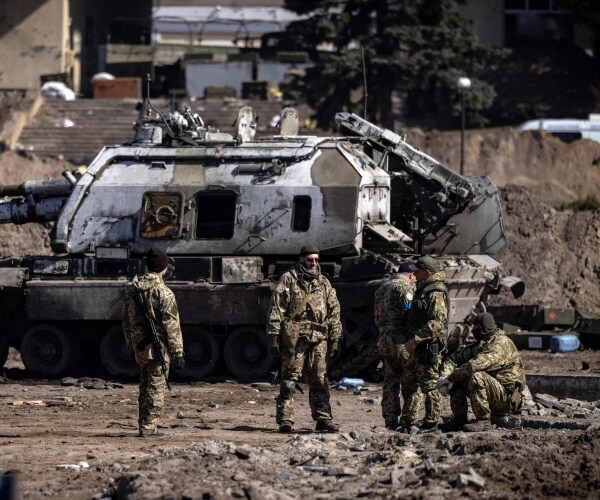 Ukrainian servicemen stand by a Russian army tank