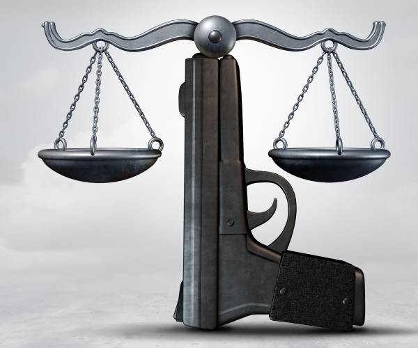 a semi automatic pistol as the base of justice scales