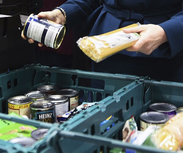 a person picks up food items at a food bank