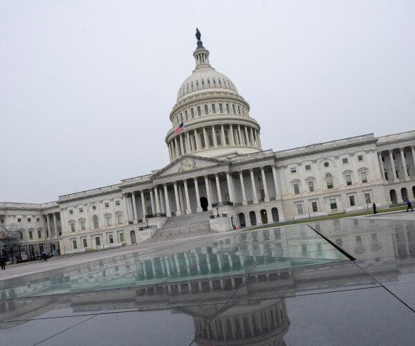 view of the capitol from outside with a reflection on the ground