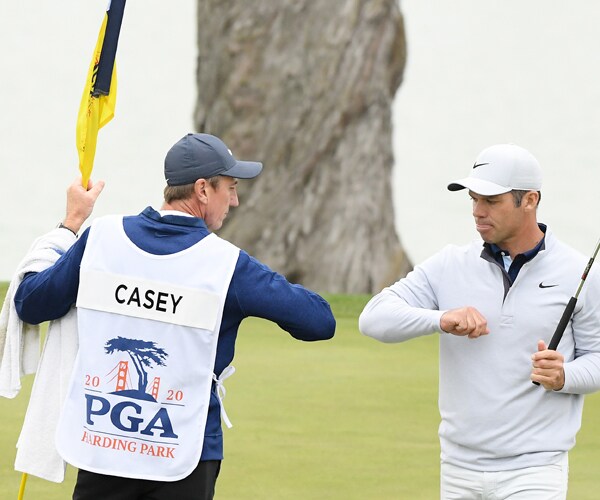 golfer paul casey gives an elbow bump to his caddy