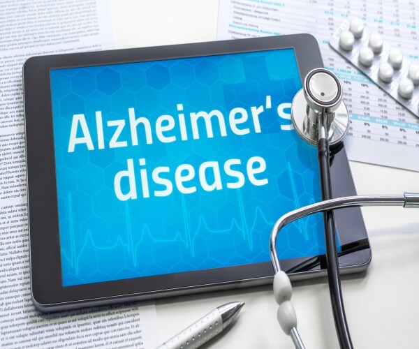 Alzheimer's disease on tablet with stethoscope and drugs around it