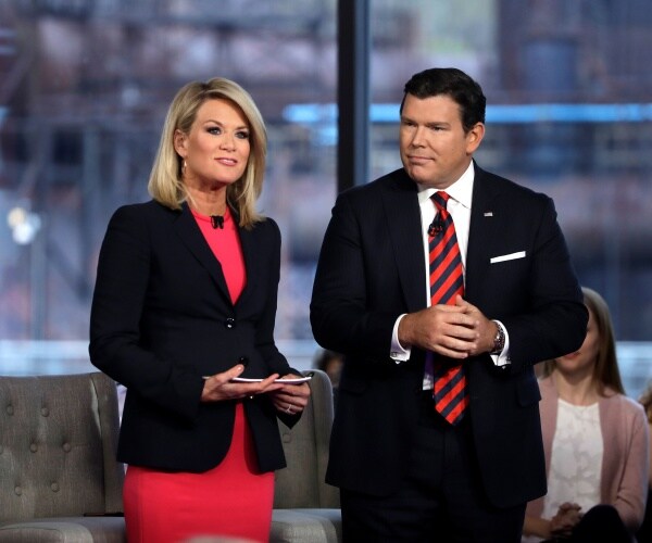 baier in a suit and striped tie standing with maccallum in a bright red dress and black blazer