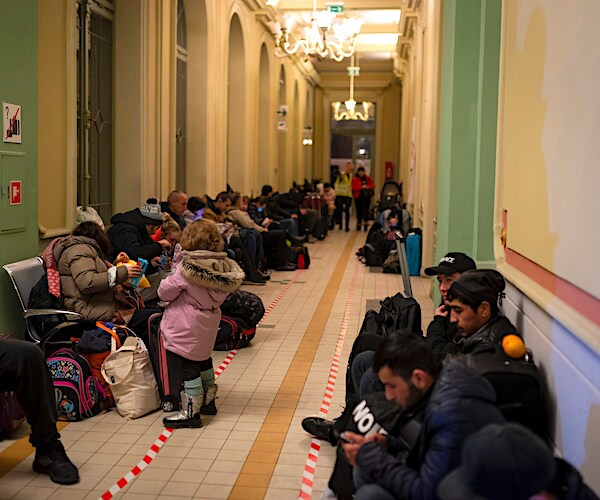 ukrainian refugees line a hallway in poland near the border in the early days of the russian invasion