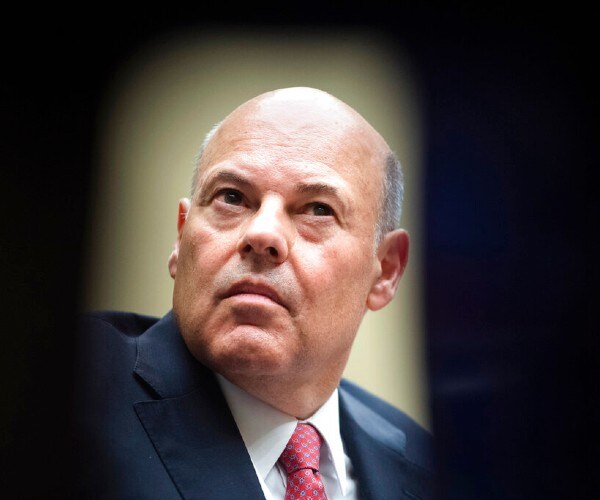 louis dejoy speaks during a congressional hearing in a photo that makes him appear as if he is in the sight of a scope