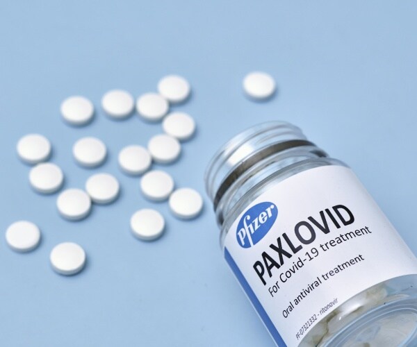 bottle of Pfizer COVID pill Paxlovid with pills on the table