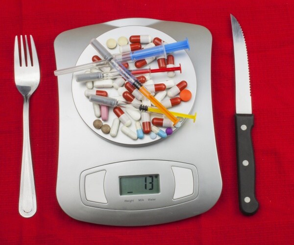 weight loss drugs, syringes, measuring tape on top of scale