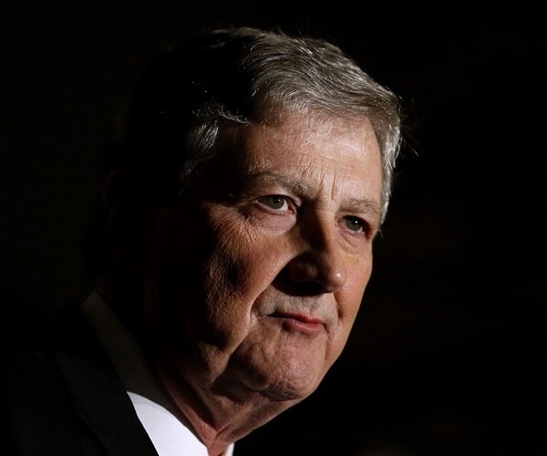 sen. john kennedy speaks against a dark background