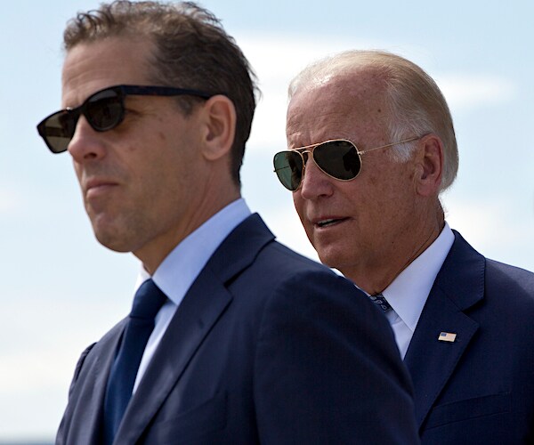 hunter and joe biden are walking and wearing dark sunglasses