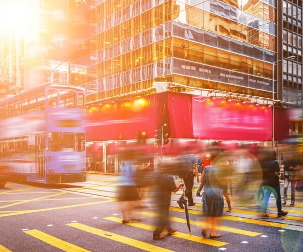 blurred view of fast-moving people, vehicles in city