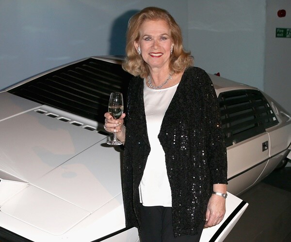 valarie leon stands in front of car at a bond exhibition