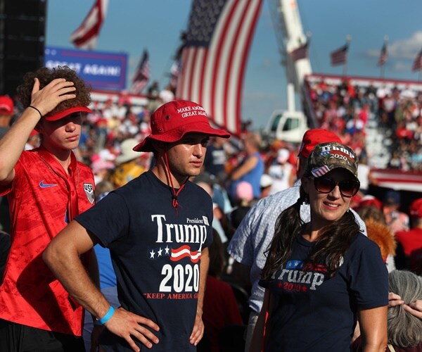 People wait for the start of a campaign rally for President Donald Trump at the Orlando Sanford International Airport