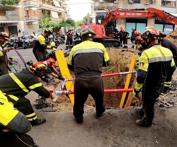 firefighters dig up a road