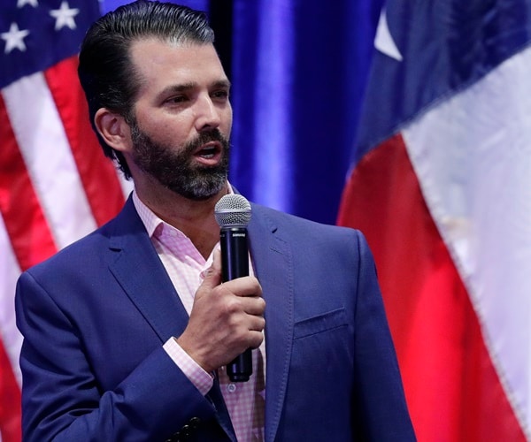 donald trump jr. speaks in front of a u.s. and texas flag