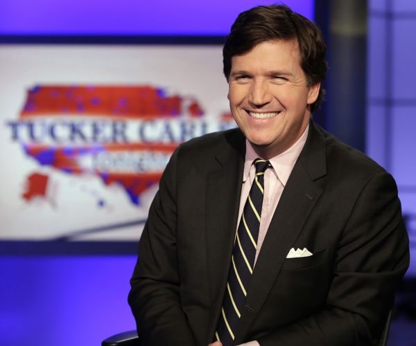 tucker carlson, host of "tucker carlson tonight," poses for photos in a fox studio. 