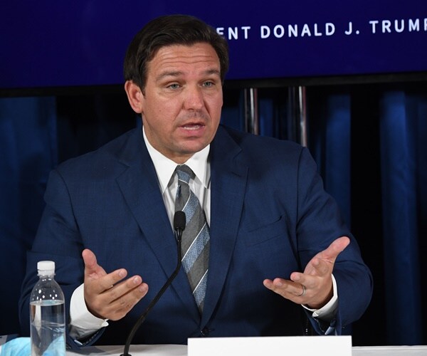 ron desantis speaks seated at a table