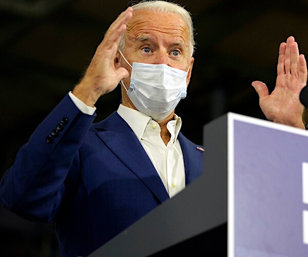 joe biden throws his hands up during a campaign rally speech