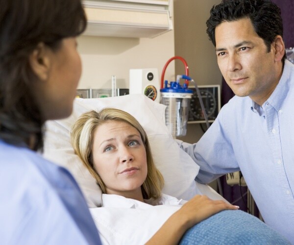 pregnant woman and her husband in hospital talking to doctor