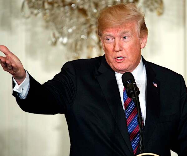 president donald trump reaches out with his right hand while addressing the media at a news conference