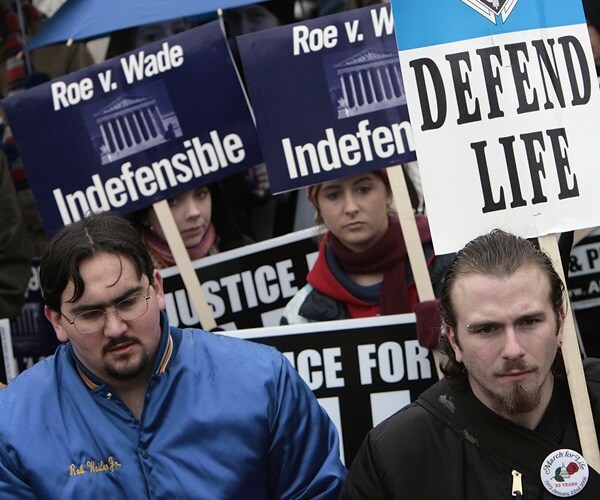 pro-life protester holding signs